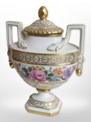 A Dresden hand-painted and gilt floral twin-handled lidded urn, height 19cm.