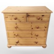 A contemporary pine five drawer chest,