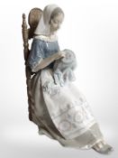A Lladró figure of a lady doing needlework.