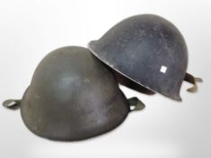 Two 20th-century military tin helmets.
