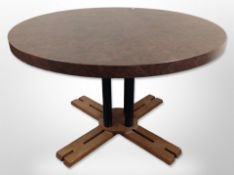 A contemporary MDF circular dining table with X-shaped pedestal base and leather effect top,