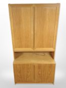 A late 20th century Danish oak veneered cabinet with cupboards beneath and above,