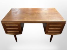 A 20th century Danish teak double sided twin-pedestal writing desk on tapered legs,
