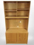 A late 20th century Danish oak veneered open bookcase with cupboards beneath,