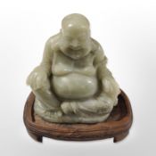 A Chinese carved hardstone figure of Buddha on hardwood base, height 20cm.