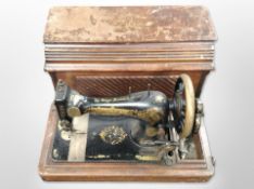 An antique Singer hand sewing machine in case