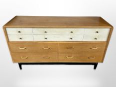 A vintage G Plan oak and teak ten drawer sideboard, designed by E Gomme, raised on ebonised legs,