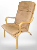 A contemporary Scandinavian laminated beech bentwood armchair with tan leather seat,