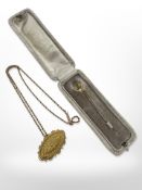 An antique 9ct gold stick pin set with peridot and seed pearl,