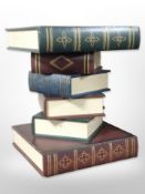 A contemporary lamp table in the form of a stack on books,