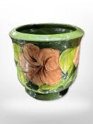 A Moorcroft plant pot on green ground, height 12.5cm.