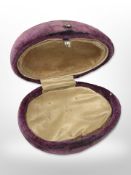 An antique ovoid purple velvet jewellery box.