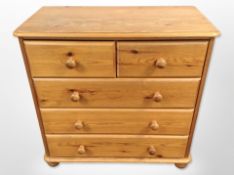A contemporary pine five drawer chest,