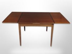 A late 20th century Danish teak pull out extending dining table,