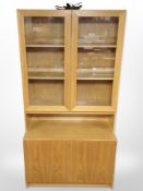 A late 20th century Danish oak veneered glazed bookcase with cupboards beneath,