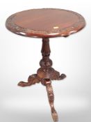 A reproduction carved mahogany tripod table, height 72cm.