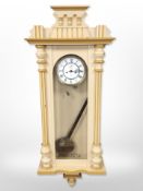 A painted Vienna-style wall clock with enamelled dial, height 120cm, with pendulum.