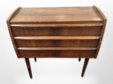 A 20th-century Danish rosewood-effect three-drawer chest on tapered legs,