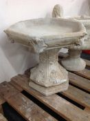 A hexagonal concrete bird bath,