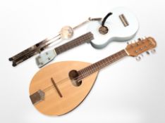 A Gremlin model CR3120 mandolin, a ukulele, and a chrome instrument stand.