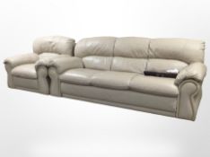 A contemporary three-seater settee and matching armchair, upholstered in stitched beige leather,