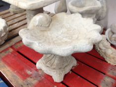 A concrete shell bird bath,