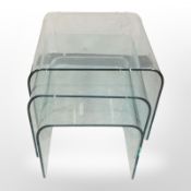 A contemporary nest of three ghost glass tables, width 55cm.