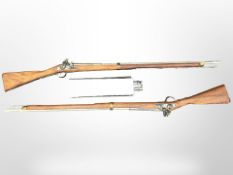 A pair of reproduction non-firing flintlock muskets, each 148cm long, with two bayonets.