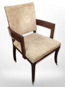 An early 20th-century mahogany-framed armchair on brass castors, width 65cm.