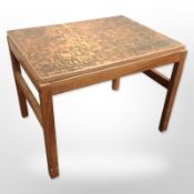 A 20th-century Danish teak lamp table with copper-effect top, width 61cm.