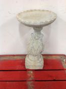 A circular concrete bird bath with acanthus leaf pedestal,