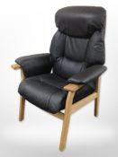 A contemporary Scandinavian oak-framed black leather armchair.