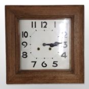 An Edwardian square oak wall clock, case 40cm wide, striking on a gong with pendulum.