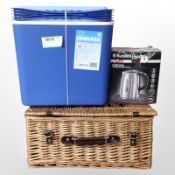 A cool box, together with a kettle and a wicker hamper.
