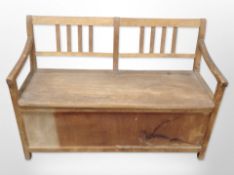 A 20th-century child's pine box settle, 89cm wide x 42cm deep x 59cm high.