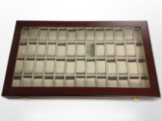 A contemporary lacquered watch display case with compartments for fifty two watches,