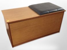 A 20th century teak blanket box with black vinyl cushion top,