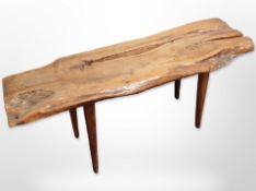 A rustic hardwood bench on tapered legs,