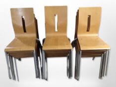 22 assorted laminated wood stacking chairs on metal legs.