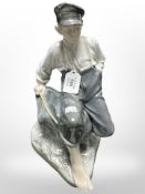 A Royal Copenhagen figure of a boy sat on a rock holding a fishing rod, No. 1659, height 32cm.