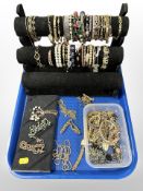A jewellery display stand containing assorted gold-plated and other bracelets,