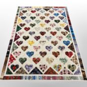 A patchwork quilt with repeat heart motif, 227cm x 165cm.