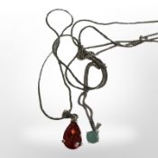 A silver chain with faceted teardrop pendant and a silver moonstone pendant.