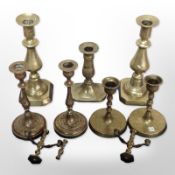 Four pairs of brass candlesticks, plus one other.