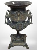 An ornate patinated bronze twin-handled vase on lion paw feet, height 31cm.