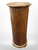 A Willis and Gambier cylindrical double door cabinet, with four internal wicker baskets,