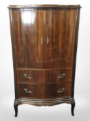 A 20th century teak serpentine front cabinet, with key,