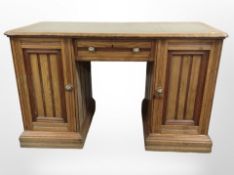 A Victorian oak twin-pedestal writing desk with green tooled inset leather panel,