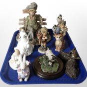 A Capodimonte figure of a tramp seated on a bench, together with other figures including Goebel,