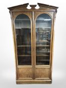 A good quality continental reproduction mahogany glazed double-door bookcase with arched pediment,